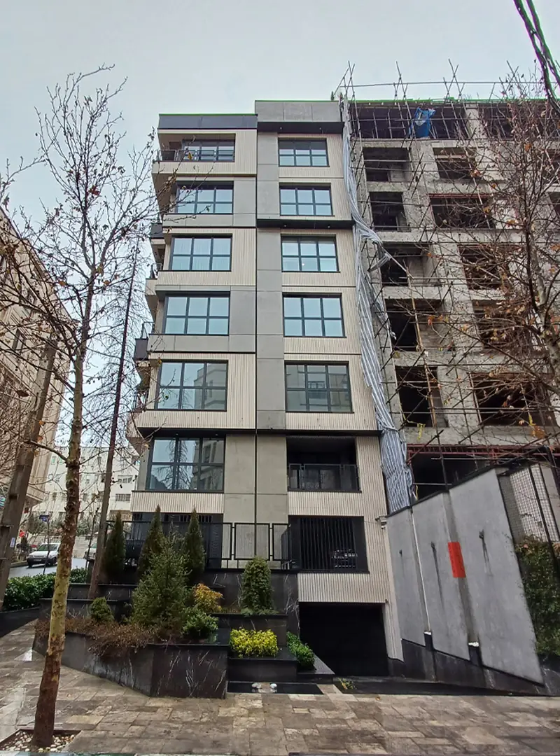 نمای بیرونی و جانبی ساختمان ام اس پی در پشت درختان زیبا در فضایی بهاری - طراحی و اجرا توسط شرکت مهندسی دیا